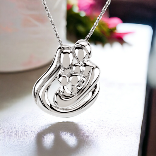 Artistic shot of a sterling silver three-children family pendant, casting a shadow of a heart, embodying the eternal circle of family love.
