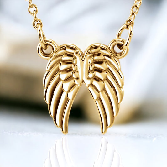 Close-up of 14K yellow gold angel wings pendant with intricate detailing, symbolizing protection and grace.