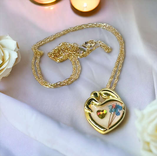 Mother's Love Breastmilk/Cremation Ash Necklace in gold, complete with chain, displayed on a table, highlighting the full elegance and craftsmanship of the memorial jewelry piece.