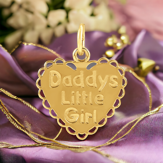 Golden heart pendant with 'Daddy's Little Girl' engraving, nestled against a purple satin backdrop with floral accents.