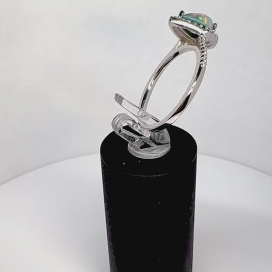 Video showcasing the Precious Drop Halo Pear Cremation Ring in Sterling Silver, rotating to display all angles. The Neptune crushed opal stone glimmers within a halo of cz stones, embodying everlasting love.