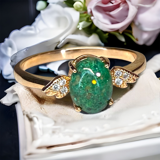 Angels Touch 14K Gold cremation ring with angel wings and custom green cremation stone featuring green sparkles. Perfect ring for breastmilk or cremation ash. Available in 14k gold or sterling silver. 