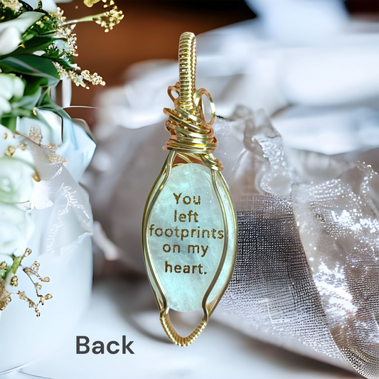 Gold quote on back reads: "You left footprints on my heart." Moonstone gemstone with rainbow flashes in 14K Gold-Filled setting with gold footprints in heart design on front.