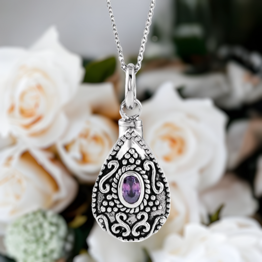 This lovely teardrop style cremation ash necklace for women is the perfect keepsake to remember a pet or loved one. Antiqued filigree design on the front.   Sterling Silver pear shaped urn pendant. Choice of 12 birthstones.
