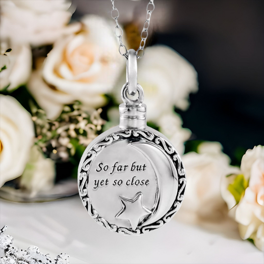 This beautiful celestial cremation ash necklace for women is the perfect keepsake to remember a pet or loved one. Antiqued Filigree front design. Star and moon with "So far but yet so close" on front. Sterling Silver pendant.