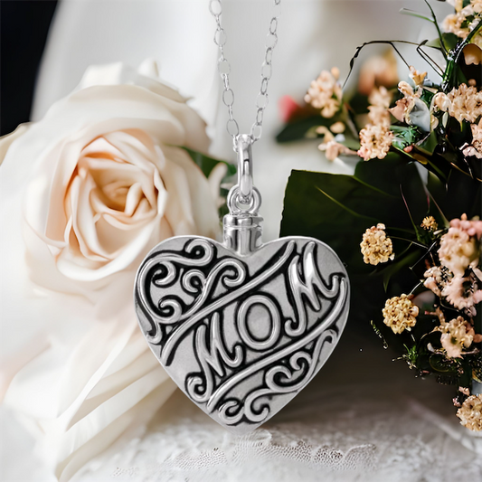 This beautiful mom cremation ash necklace for women is the perfect keepsake to remember a mother who has departed. Antiqued scroll design on front of heart. "Mom" on the front center. Sterling Silver pendant. 